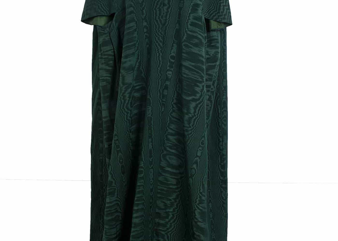 A full-length green kaftan dress displayed on a stand