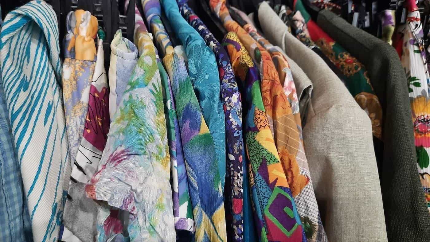 Vintage printed tops and blouses on a rack in a second-hand shop