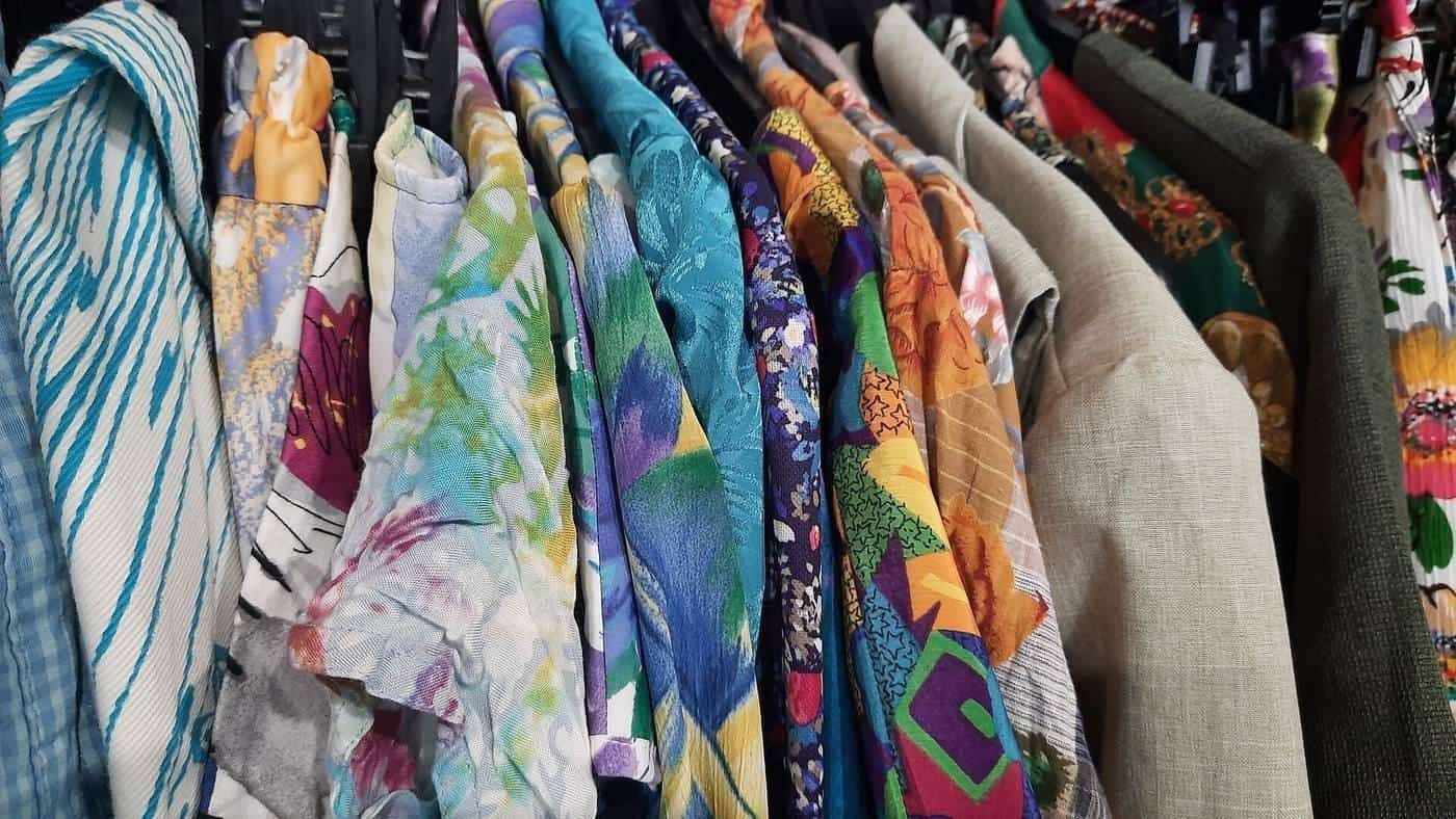 Vintage printed tops and blouses on a rack in a second-hand shop